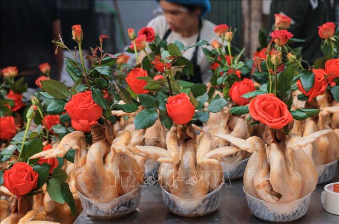 Chuẩn bị gà ngậm hoa sen, buộc cánh tiên tại chợ Hàng Bè trong phiên chợ cuối năm. Ảnh: Hoàng Hiếu - TTXVN