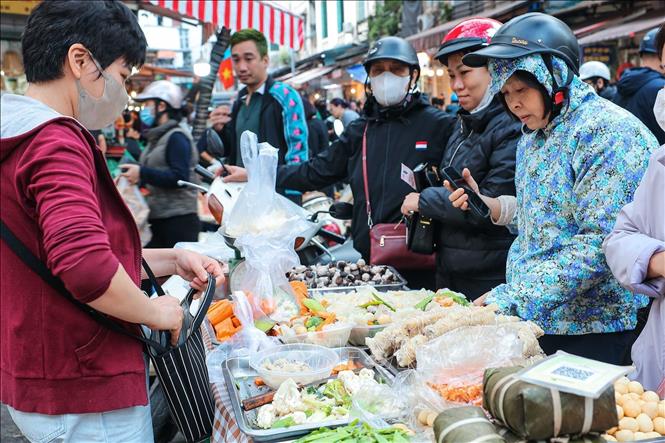 Người dân chọn mua thực phẩm về để sửa soạn mâm cỗ tưởng nhớ tổ tiên. Ảnh: Hoàng Hiếu - TTXVN