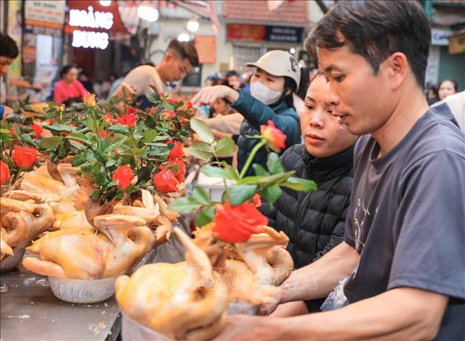 Nhiều người đến chọn mua gà - món không thể thiếu trong mâm cỗ cúng của người Việt. Ảnh: Hoàng Hiếu - TTXVN