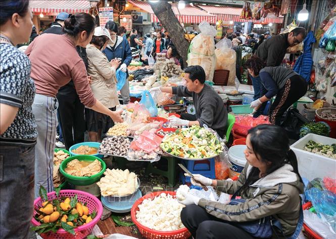 Nhiều người dân có thói quen đi chợ để sắm sửa thực phẩm chuẩn bị cho mâm cơm cúng tất niên và lễ cúng giao thừa, thể hiện lòng thành kính với tổ tiên. Ảnh: Hoàng Hiếu - TTXVN