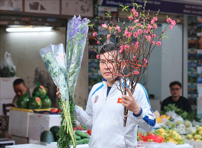 Theo phong tục truyền thống, người dân thường chọn mua những bó hoa tươi trong phiên chợ cuối năm để trang hoàng nhà cửa và dâng lên bàn thờ gia tiên. Ảnh: Hoàng Hiếu - TTXVN
