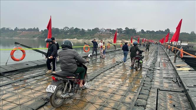 Người và phương tiện lưu thông bình thường qua cầu phao sông Lô sáng 16/2. Ảnh: Nguyễn Văn Cảnh - TTXVN
