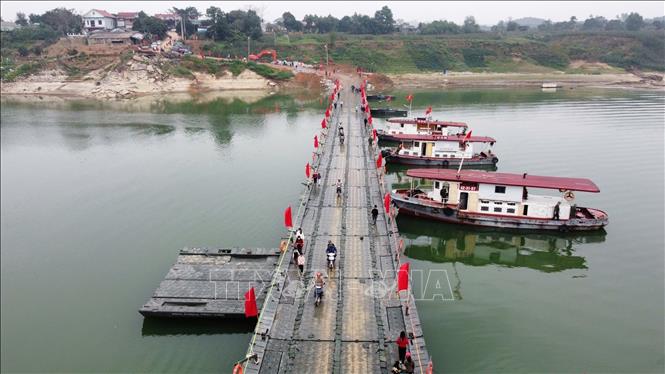 Người và phương tiện lưu thông bình thường qua cầu phao sông Lô sáng 16/2. Ảnh: Nguyễn Văn Cảnh - TTXVN