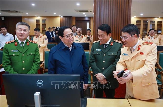 Thủ tướng Phạm Minh Chính thực hiện thao tác nhắn tin chúc Tết người tham gia giao thông qua ứng dụng giao thông. Ảnh: Dương Giang-TTXVN 
