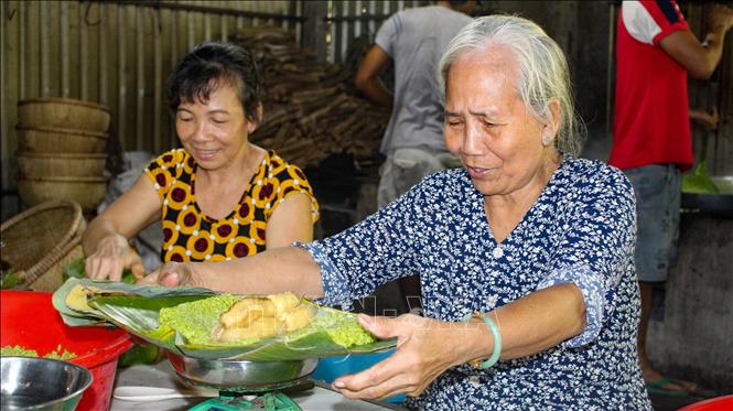 Người thợ kiểm tra kỹ định lượng và chất lượng nguyên liệu trước khi gói bánh, nhằm bảo đảm mỗi đòn bánh tét đạt độ đồng đều, ổn định. Ảnh: Minh Phú - TTXVN