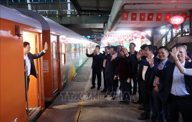 Các đại biểu và nhân viên ga Hà Nội vẫy tay chào Chúc mừng năm mới đến với toàn thể hành khách trên tàu. Ảnh: Quốc Khánh - TTXVN