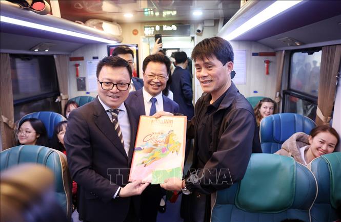 Tổng biên tập Báo Nhân Dân Lê Quốc Minh tặng ấn phẩm báo Nhân Dân cho hành khách trên tàu. Ảnh: Quốc Khánh - TTXVN