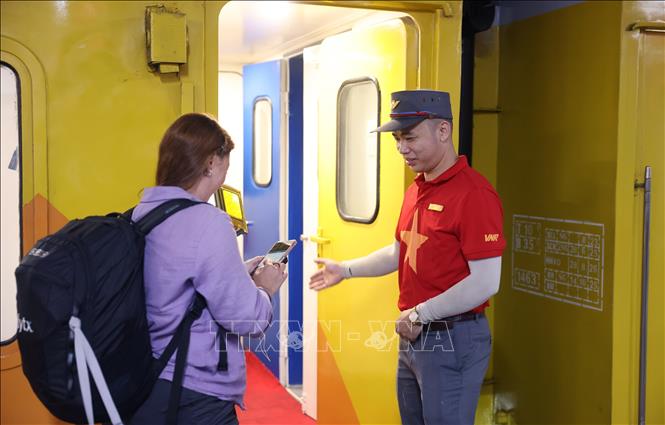 Nhân viên tàu kiếm tra vé, hướng dẫn nhân dân lên tàu. Ảnh:Quốc Khánh - TTXVN