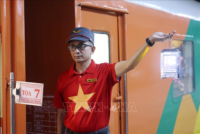 Nhân viên tàu ra ký hiệu Chuyến tàu Hạnh phúc chuẩn bị rời Ga Hà Nội. Ảnh: Quốc Khánh - TTXVN