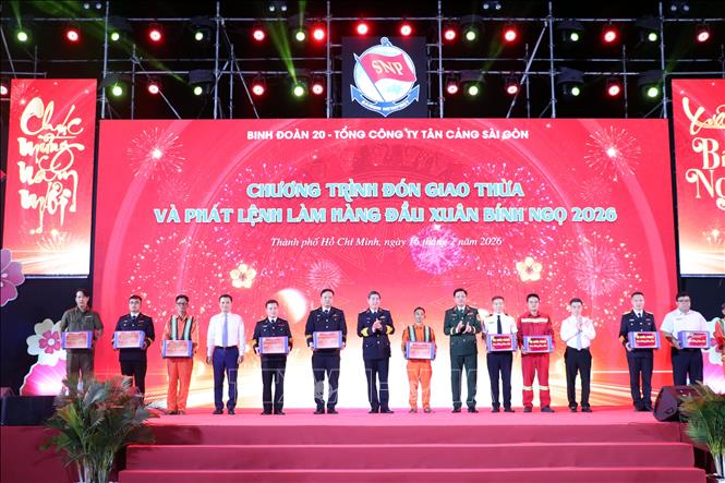 Tặng quà cho các đơn vị trong dây chuyền sản xuất đêm giao thừa. Ảnh: Tiến Lực - TTXVN