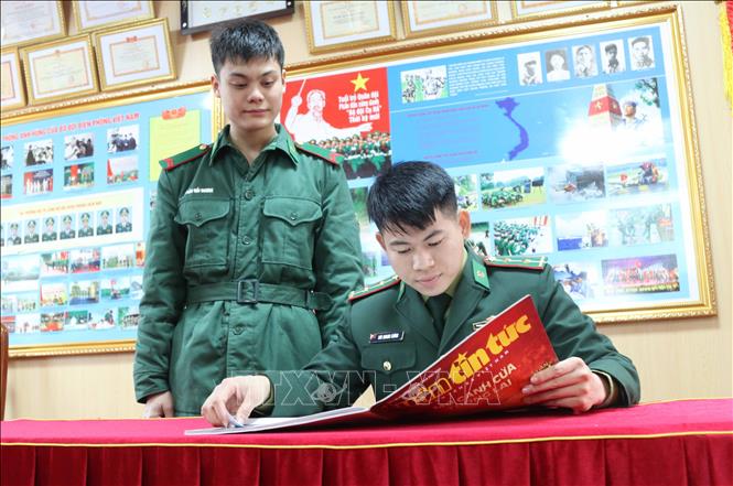 Cán bộ, chiến sĩ Đồn Biên phòng Cửa khẩu quốc tế Hữu Nghị (Lạng Sơn) tìm hiểu văn hóa đồng bào các dân tộc Việt Nam qua tờ báo Tết. Ảnh: Quang Duy - TTXVN