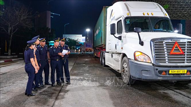 Lãnh đạo và cán bộ Chi cục Hải quan khu vực 17 phối hợp kiểm tra phương tiện vận tải hàng hóa tại cửa khẩu trong đêm trực Tết. Ảnh: Minh Phú – TTXVN