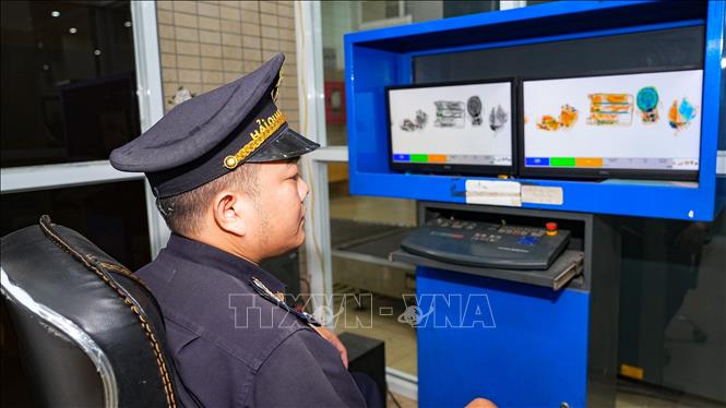 Cán bộ hải quan Cửa khẩu quốc tế Mộc Bài thực hiệm giám sát hàng quá qua máy soi chiếu trong ca trực Tết. Ảnh: Minh Phú - TTXVN