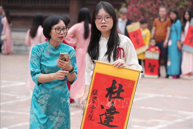 Người dân thủ đô xin chữ đầu năm tại Văn Miếu - Quốc Tử Giám (Hà Nội) là nét văn hóa truyền thống đặc sắc để cầu may mắn, trí tuệ và bình an. Ảnh: Minh Đức - TTXVN