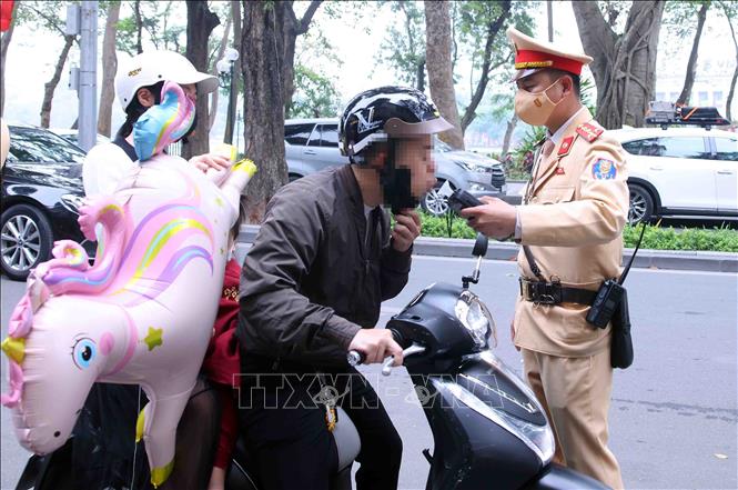 Cán bộ, chiến sĩ Đội CSGT số 1, Công an Hà Nội kiểm tra nồng độ cồn với người tham gia giao thông vào sáng mùng 1 Tết. Ảnh: Phạm Kiên - TTXVN