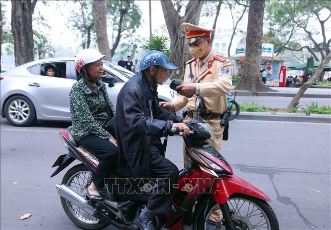 Cán bộ, chiến sĩ Đội Cảnh sát giao thông số 1, Công an Hà Nội kiểm tra nồng độ cồn với người tham gia giao thông vào sáng mùng 1 Tết. Ảnh: Phạm Kiên - TTXVN