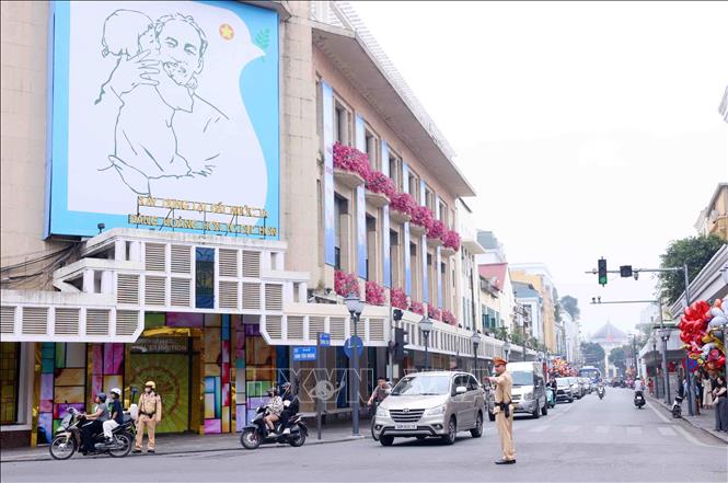 Lực lượng Cảnh sát giao thông điều tiết, phân luồng giao thông tại nút giao phố Tràng Tiền - Đinh Tiên Hoàng, Hà Nội trong sáng mùng 1 Tết. Ảnh: Phạm Kiên - TTXVN