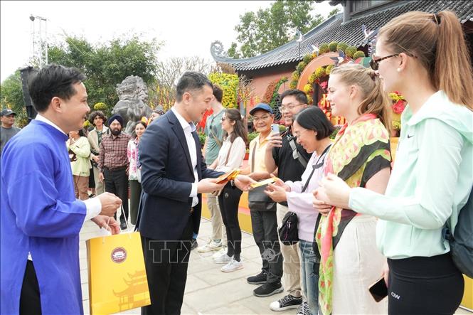 Ông Bùi Văn Mạnh, Giám đốc Sở Du lịch Ninh Bình lì xì và chúc các du khách gặp nhiều  may mắn trong năm mới. Ảnh: Đức Phương - TTXVN