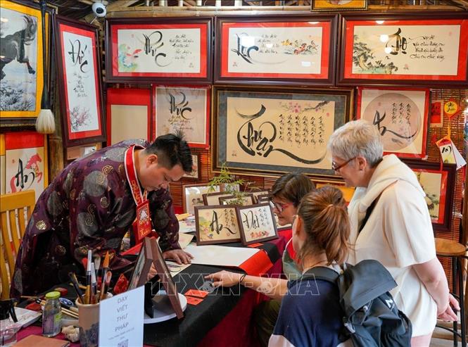 Du khách thích thú với phong tục xin chữ đầu năm của người Việt. Ảnh: Khánh Hoà - TTXVN