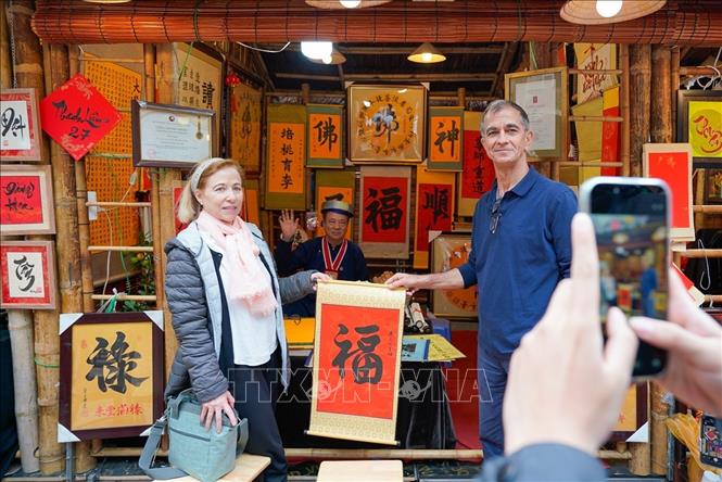 Du khách thích thú với phong tục xin chữ đầu năm của người Việt. Ảnh: Khánh Hoà - TTXVN