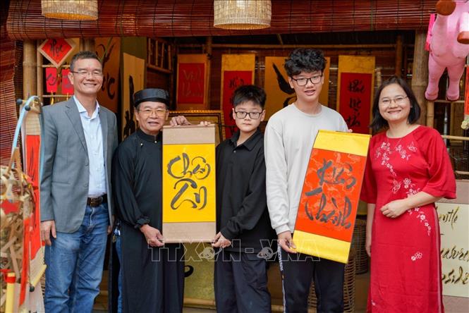 Một gia đình xin chữ đầu năm tại Không gian Hồ Văn, Di tích Quốc gia đặc biệt Văn Miếu – Quốc Tử Giám (Hà Nội) ngày mùng 2 Tết Bính Ngọ. Ảnh: Khánh Hoà - TTXVN