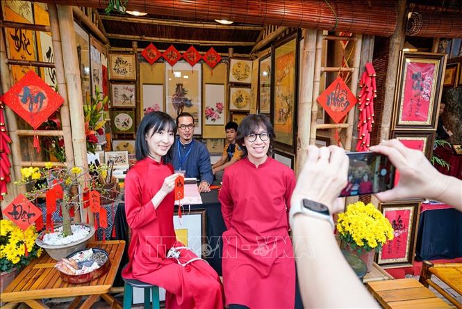 Du khách thích thú với phong tục xin chữ đầu năm của người Việt. Ảnh: Khánh Hoà - TTXVN