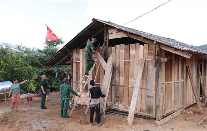Cán bộ, chiến sĩ Đồn Biên phòng Pa Tần hỗ trợ giúp dân dựng những nếp nhà mới giúp dân ổn định cuộc sống. Ảnh: Quý Trung – TTXVN