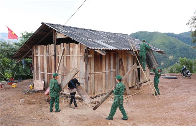 Cán bộ, chiến sĩ Đồn Biên phòng Pa Tần hỗ trợ giúp dân dựng những nếp nhà mới giúp dân ổn định cuộc sống. Ảnh: Quý Trung – TTXVN