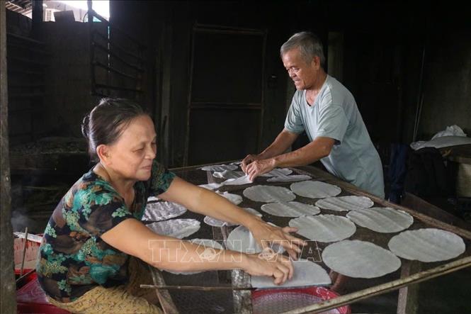 Nghệ nhân cần mẫn làm từng chiếc bánh tráng truyền thống. Ảnh: Văn Dũng-TTXVN