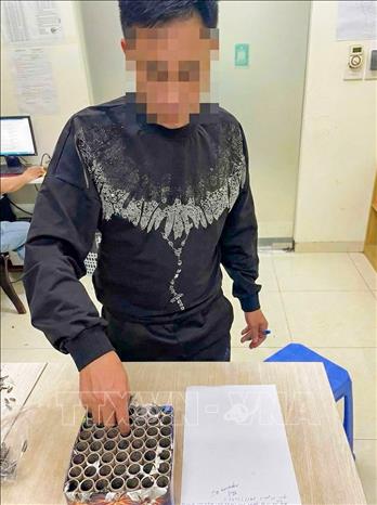 Anh N. D.T cùng xác pháo thu giữ tại trụ sở Công an phường Yên Nghĩa (Hà Nội). Ảnh: TTXVN phát