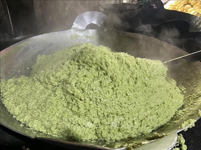 Công đoạn xào nếp với nước cốt dừa và nước cốt lá dứa trước khi gói bánh. Ảnh: Đức Hạnh - TTXVN 