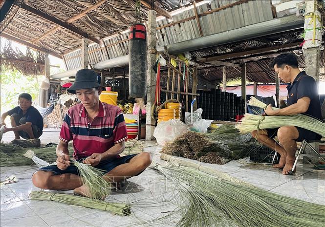 Nhân công chuẩn bị lạt gói bánh. Ảnh: Đức Hạnh - TTXVN 