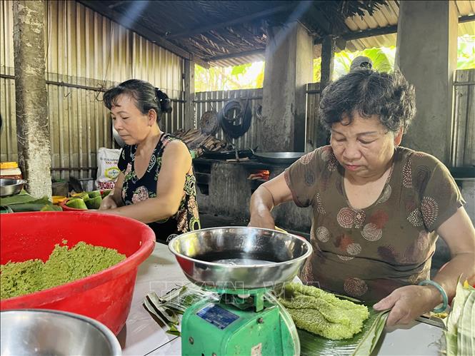 Bà Phạm Thị Nữa (sinh năm 1960) đã gắn bó với xưởng bánh tét Cô Bé 8 năm, có thu nhập ổn định. Ảnh: Đức Hạnh - TTXVN 