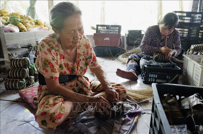 Mẹ của bà Ngô Thị Ánh Hồng – năm nay đã 84 tuổi – vẫn thoăn thoắt gói bánh tét. Ảnh: Đức Hạnh - TTXVN 