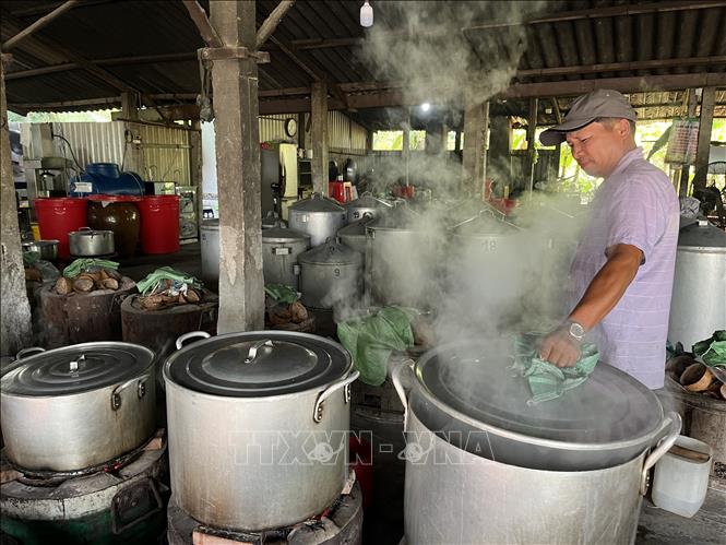 Kiểm tra nhiệt độ nấu bánh. Ảnh: Đức Hạnh - TTXVN 