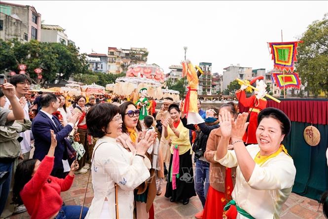 Người dân và du khách trải nghiệm điều khiển trực tiếp các con rối. Ảnh: Khánh Hoà - TTXVN