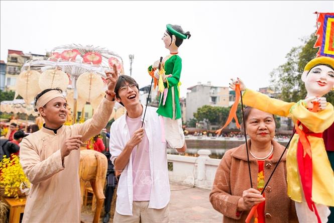 Người dân trải nghiệm điều khiển trực tiếp các con rối. Ảnh: Khánh Hoà - TTXVN