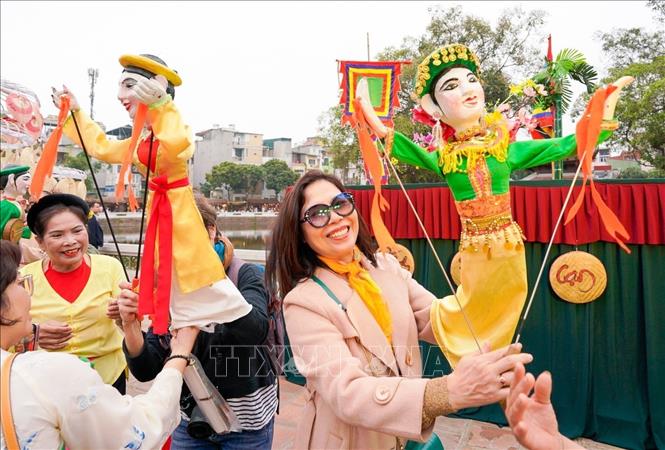 Người dân và du khách trải nghiệm điều khiển trực tiếp các con rối. Ảnh: Khánh Hoà - TTXVN