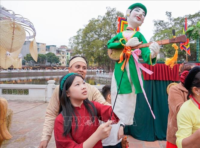 Người dân trải nghiệm điều khiển trực tiếp các con rối. Ảnh: Khánh Hoà - TTXVN