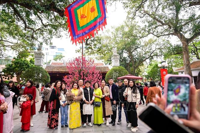 Người dân lưu lại khoảnh khắc đầu Xuân đi lễ đền Quán Thánh (trấn Bắc) ngày mùng 2 Tết Bính Ngọ. Ảnh: Khánh Hoà - TTXVN