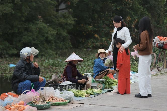 Người đi bộ, người đi xe, tay xách nách mang, ai cũng rạng rỡ trong bộ quần áo mới, ánh mắt ánh lên niềm vui đầu năm. Ảnh: Minh Quyết - TTXVN