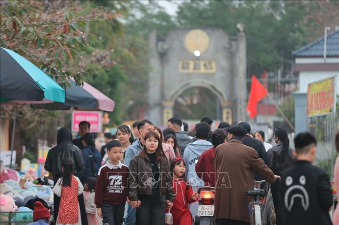 Người đi bộ, người đi xe, tay xách nách mang, ai cũng rạng rỡ trong bộ quần áo mới, ánh mắt ánh lên niềm vui đầu năm. Ảnh: Minh Quyết - TTXVN