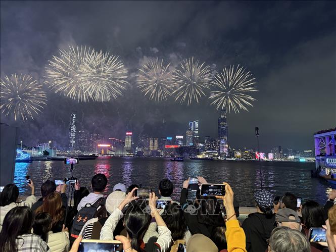 Người dân và du khách ghi lại khoảnh khắc pháo hoa rực sáng trên vịnh Victoria. Ảnh: Mạc Luyện - PV TTXVN tại Hong Kong 