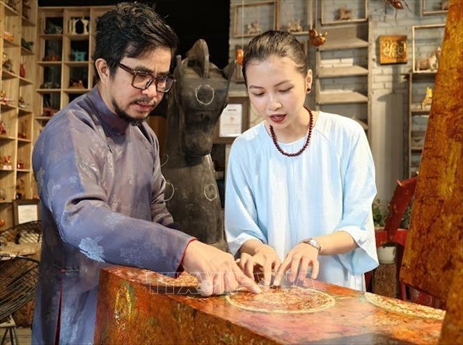 Nghệ nhân ưu tú Nguyễn Tấn Phát giới thiệu với khách hàng về ý nghĩa của văn hoa trên sản phẩm bộ sưu tập 