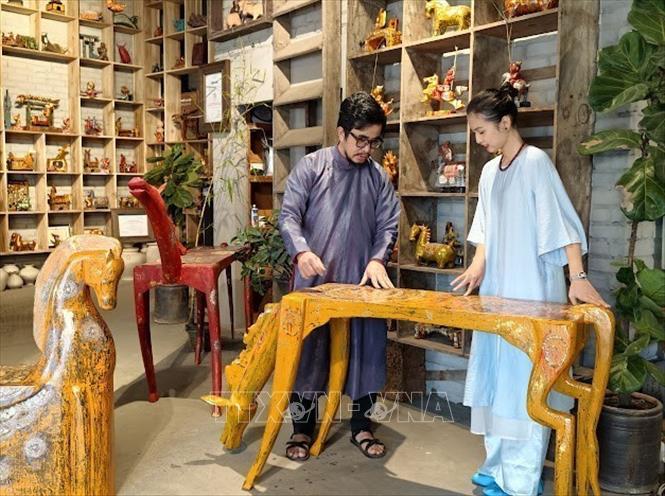 Nghệ nhân ưu tú Nguyễn Tấn Phát đang giới thiệu ý nghĩa của bộ sưu tập sơn mài “Gióng”. Ảnh: Quốc Lũy - TTXVN