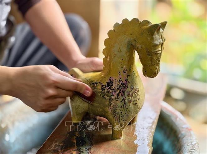 Nghệ nhân ưu tú Nguyễn Tấn Phát đang thực hiện công đoạn mài sản phẩm . Ảnh: Quốc Lũy - TTXVN