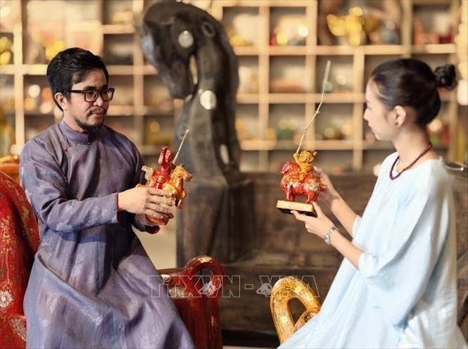 Nghệ nhân ưu tú Nguyễn Tấn Phát giới thiệu với khách hàng về hình tượng ngựa  