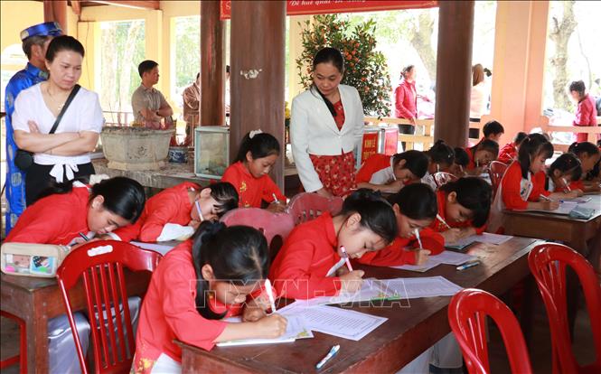 Hội thi viết chữ đẹp tại lễ hội. Ảnh: Tường Vi - TTXVN