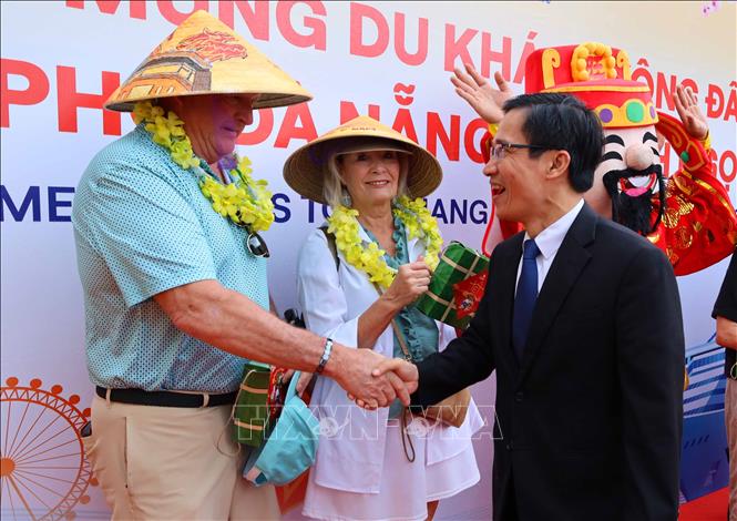 Ông Tán Văn Vương, Phó Giám đốc Sở Văn hóa, Thể thao và Du lịch thành phố Đà Nẵng tặng quà và chúc mừng các du khách đến tham quan Đà Nẵng trong dịp Xuân mới Bính Ngọ 2026. Ảnh: Trần Lê Lâm - TTXVN 