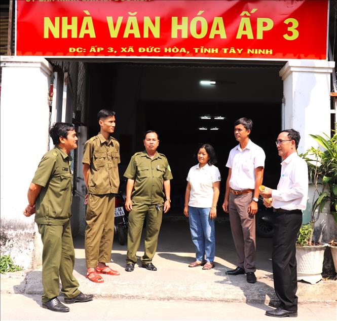 Ông Nguyễn Hoài Trung, Bí thư Chi bộ, Trưởng khu phố 3, xã Đức Hòa, tỉnh Tây Ninh cùng tổ an ninh tự quản khu phố trao đổi thông tin. Ảnh: Thanh Bình - TTXVN